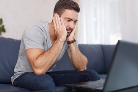 Man read bad news on laptop indoors, freelance job failed